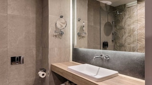 A modern bathroom with a large mirror, a sink, and a toilet. There are towels and toiletries on the vanity. - Mercure Sofia City  (Sofia)