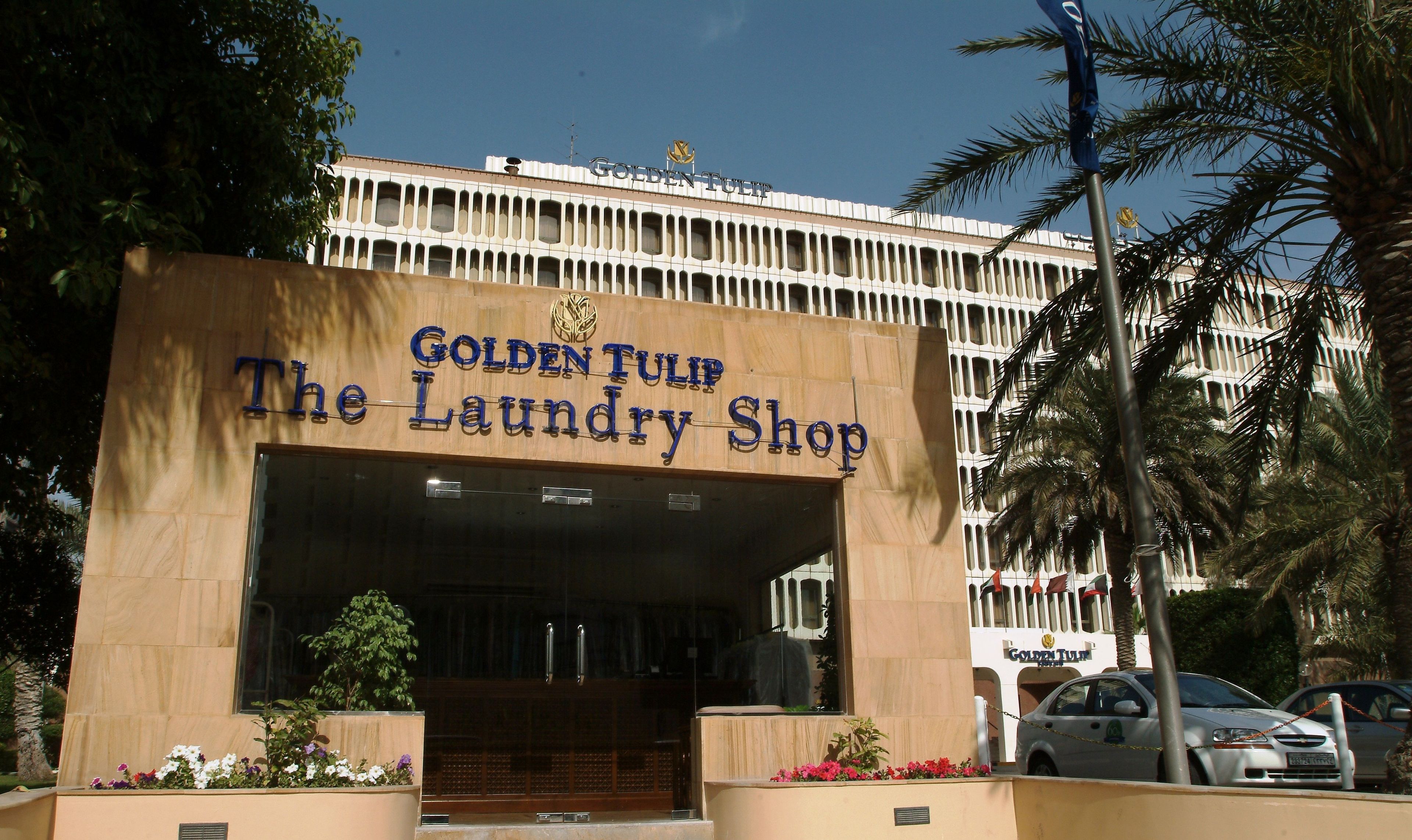 Exterior del Golden Tulip The Laundry Shop, con una entrada destacada y un letrero sobre la puerta.