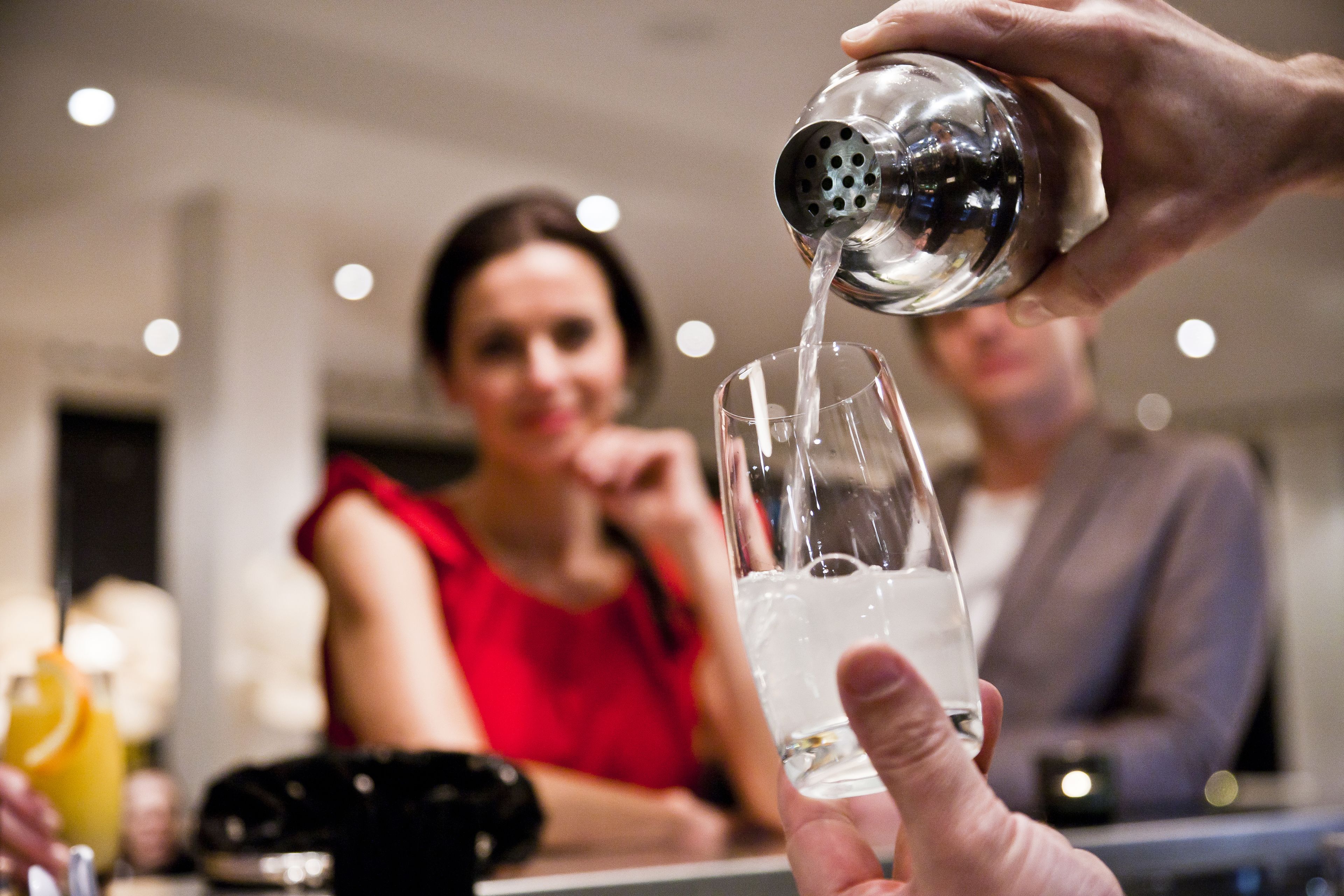 Una persona vertiendo un líquido transparente en un vaso.