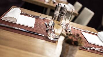 A dining table set with cutlery, glasses, and a napkin.