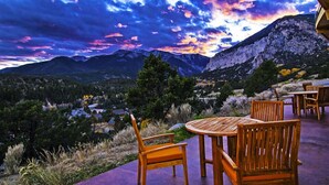 Un conjunto de mesa y sillas de madera al aire libre, con vistas a la montaña.