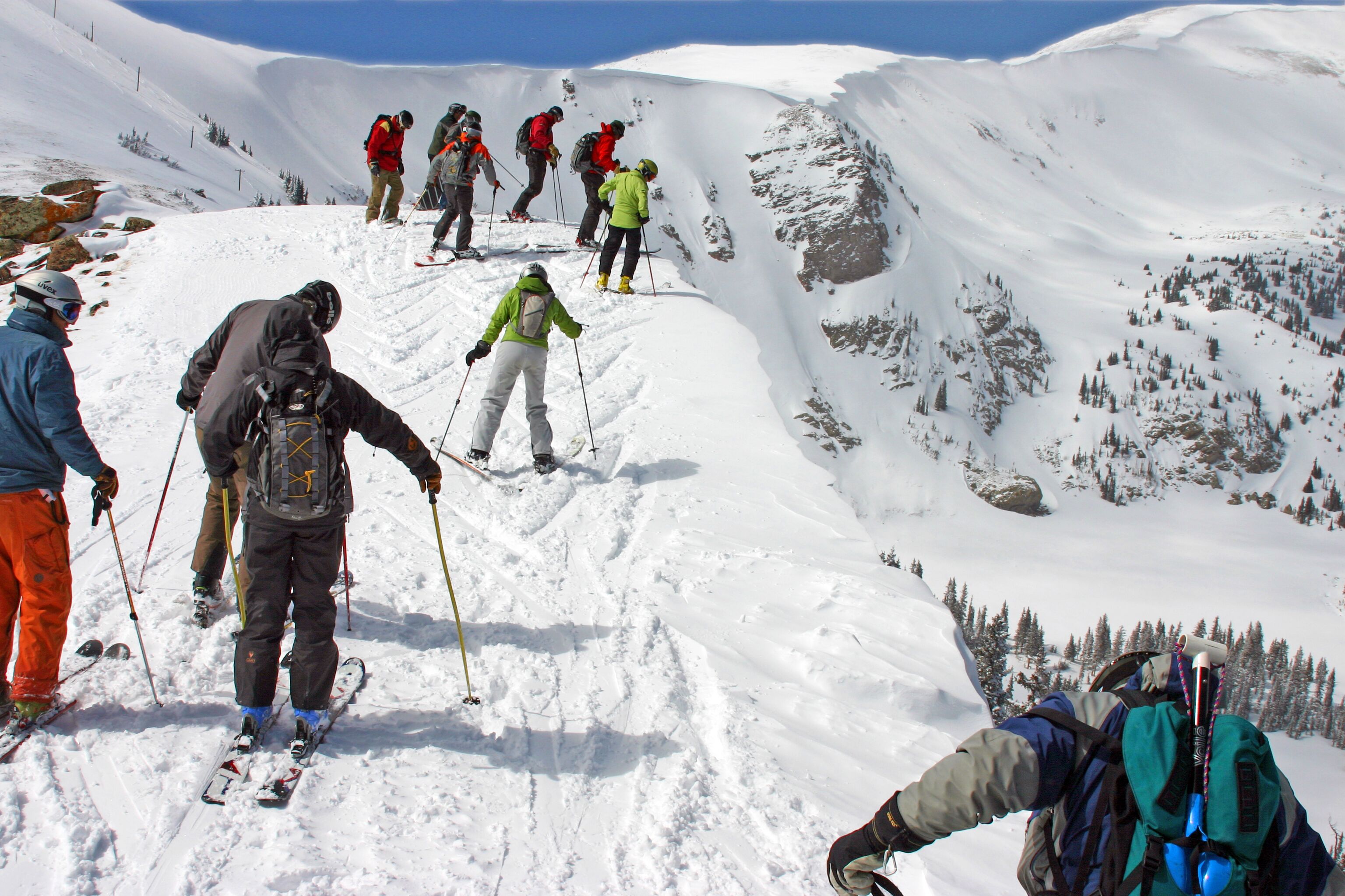 Un grupo de esquiadores en una ladera nevada de montaña.