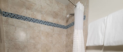 Un baño con bañera, inodoro y cortina de ducha.