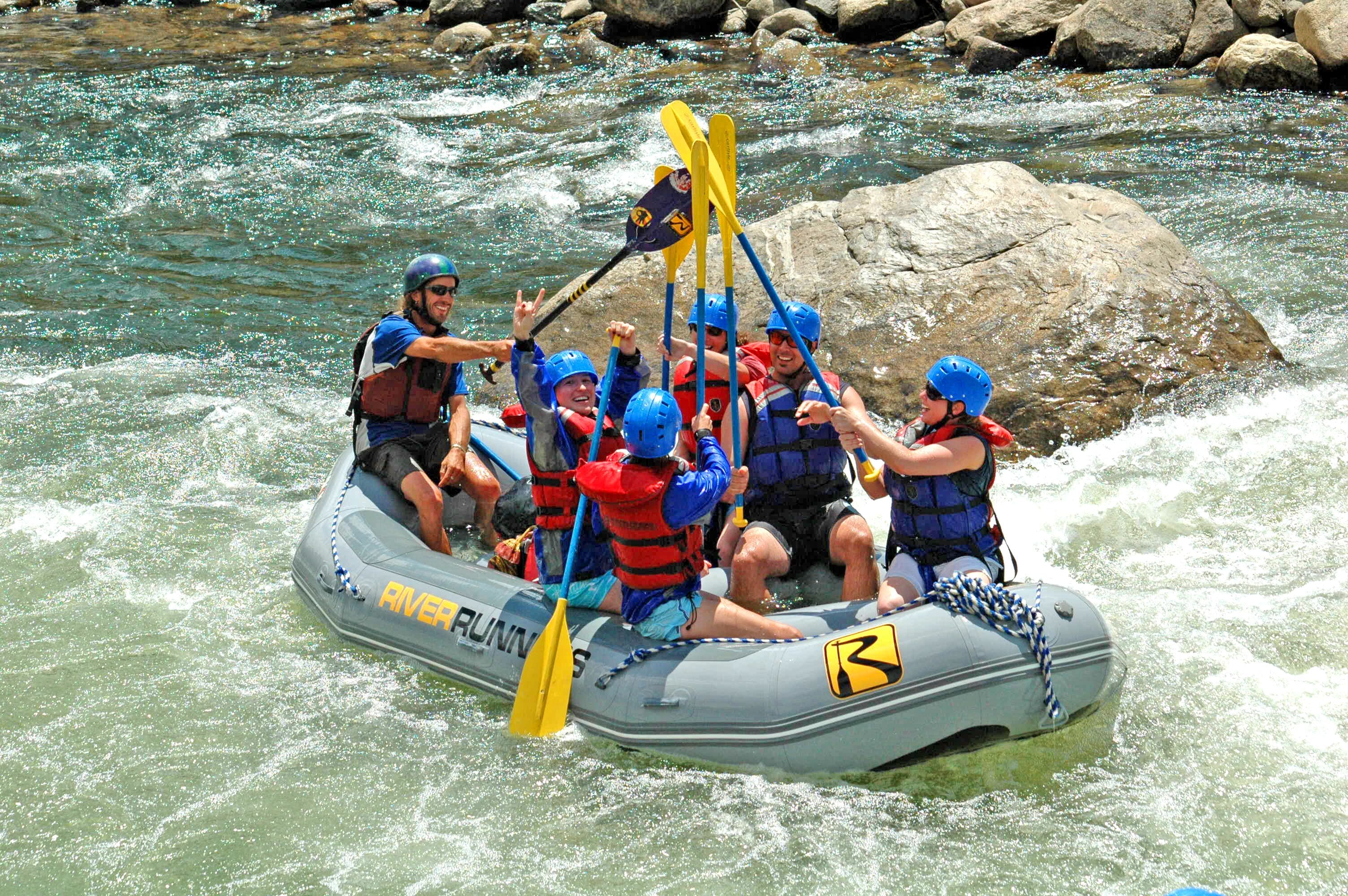 A group of people in a raft navigating a river.