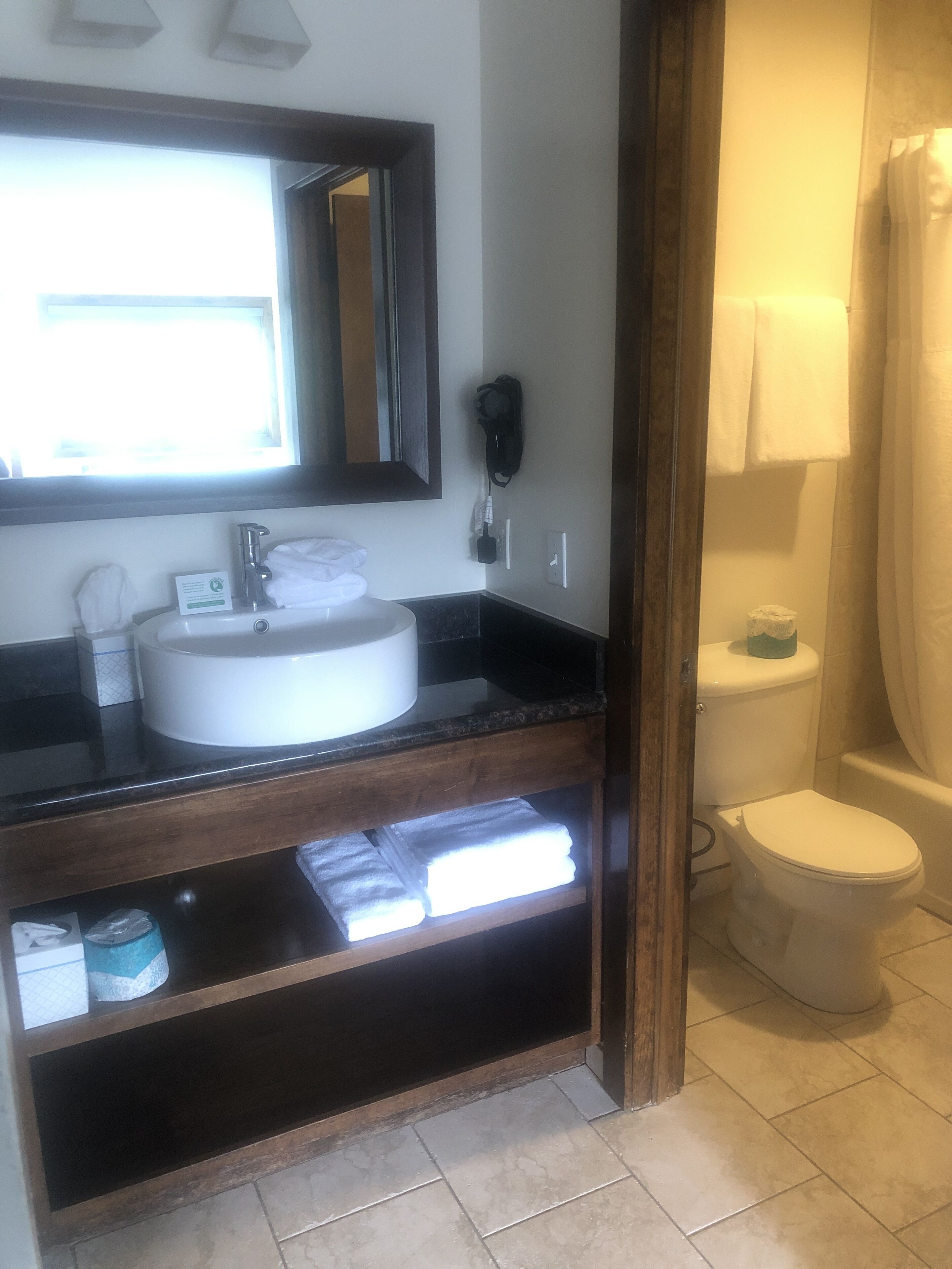 Un baño con lavabo, espejo e inodoro.