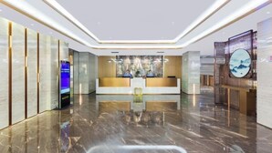 A modern hotel lobby with a reception desk, seating area, and decorative elements. - New TianHe Hotel (Guangzhou)
