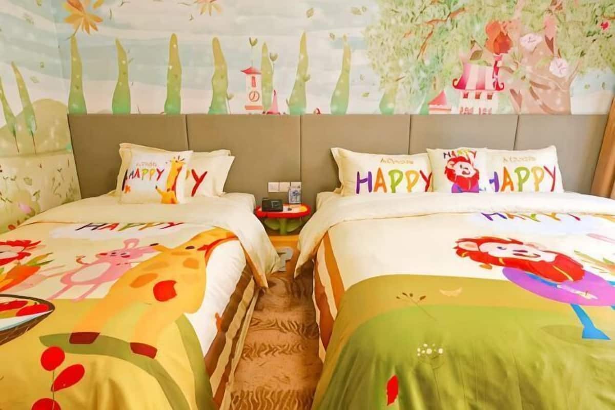 A double room with two beds, each with a colorful bedspread and matching pillows.
