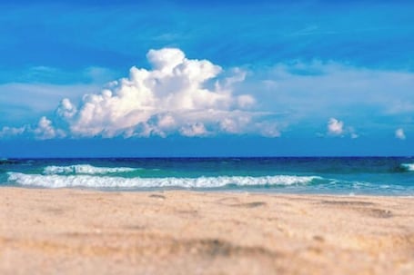 A beach with a clear sky and ocean waves.. Orient Haitian Guibin Hotel