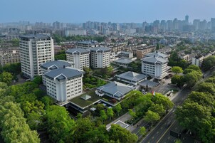 Complejo residencial de edificios de gran altura con varias torres de apartamentos, rodeado de vegetación y una vista despejada del horizonte urbano.