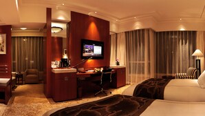 A hotel room with a bed, desk, chair, TV, and curtains. - The Dragon Hotel (Hangzhou)