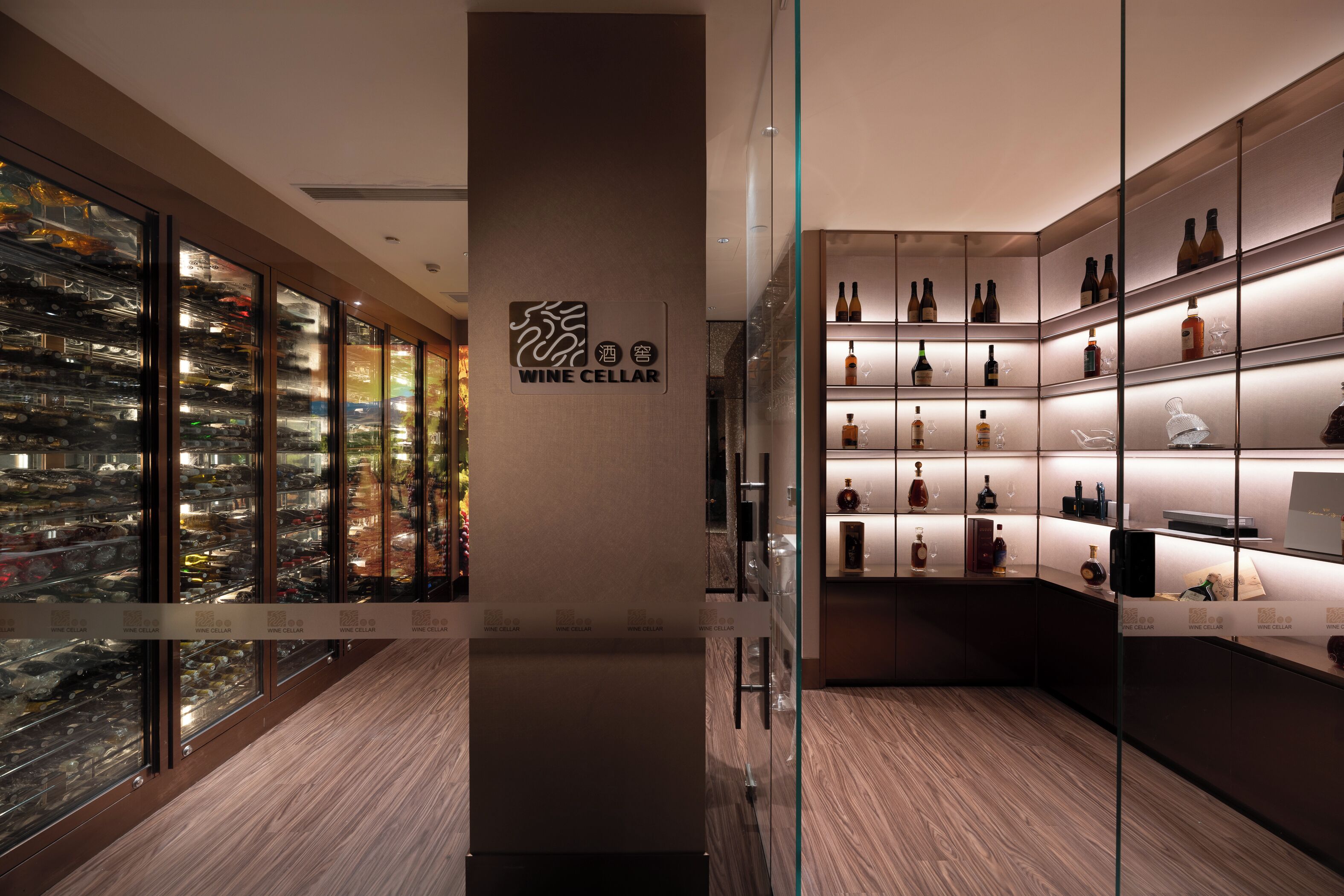 A wine cellar with glass-fronted racks of wine bottles and a sign reading 'WINE CELLAR'.
