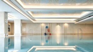 A modern indoor swimming pool with clear water, a glass floor, and a minimalist design. - The Dragon Hotel (Hangzhou)