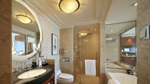 A modern bathroom with a large mirror, a sink, a toilet, a shower, and a bathtub. - The Dragon Hotel (Hangzhou)