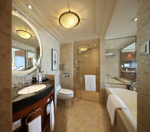 Ein modernes Badezimmer mit großem Spiegel, Waschbecken, Toilette, Dusche und Badewanne.