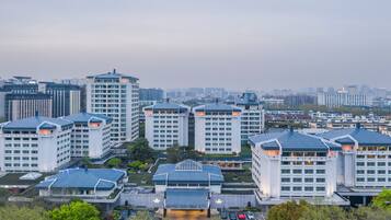A high-rise hotel complex with multiple buildings, a parking area, and surrounding greenery.