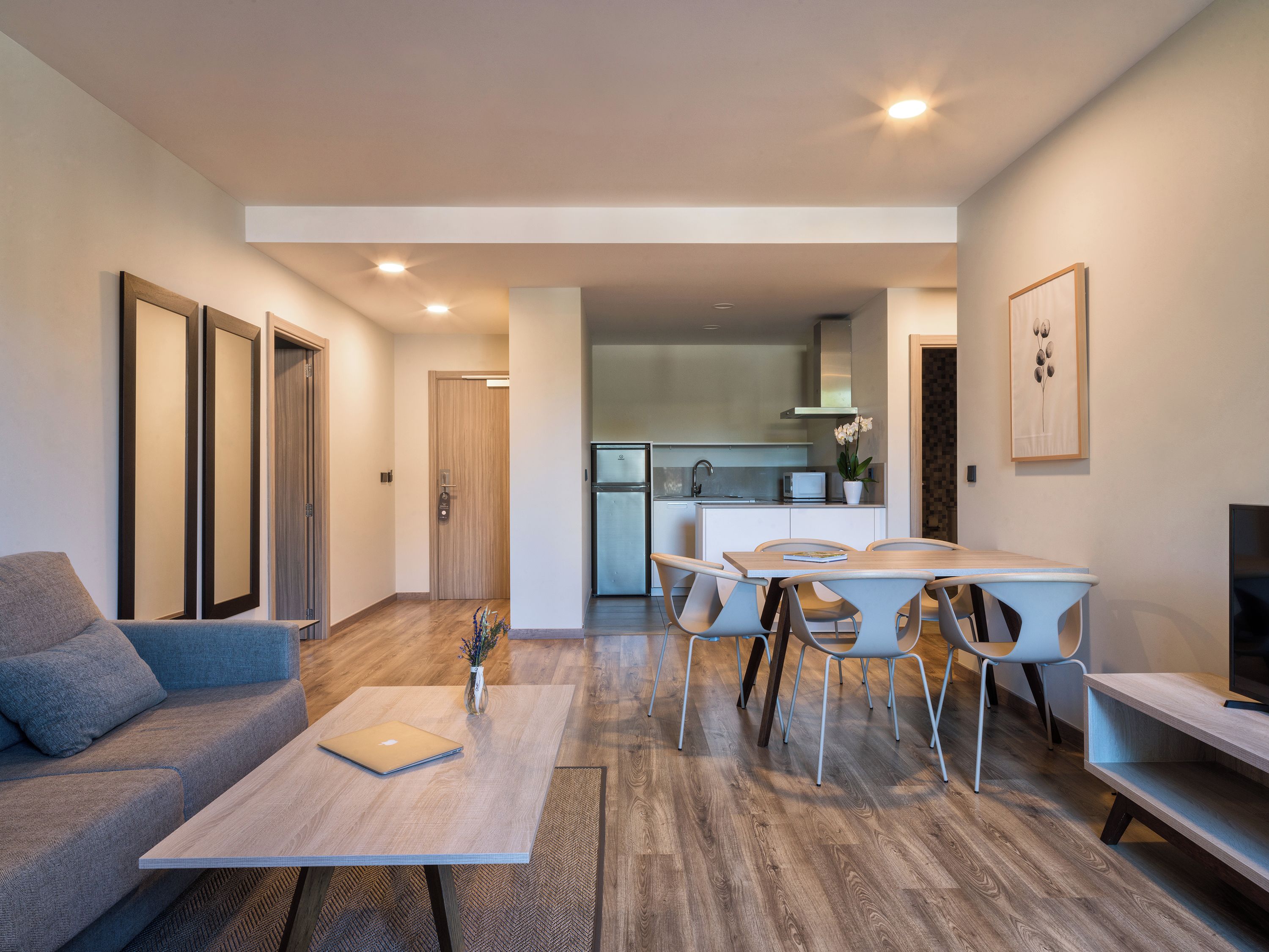 Una sala moderna con un sofá, una mesa de centro y un comedor con sillas y una mesa.