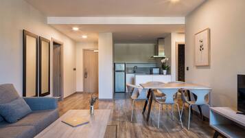 Una sala moderna con un sofá, una mesa de centro y un comedor con sillas y una mesa.