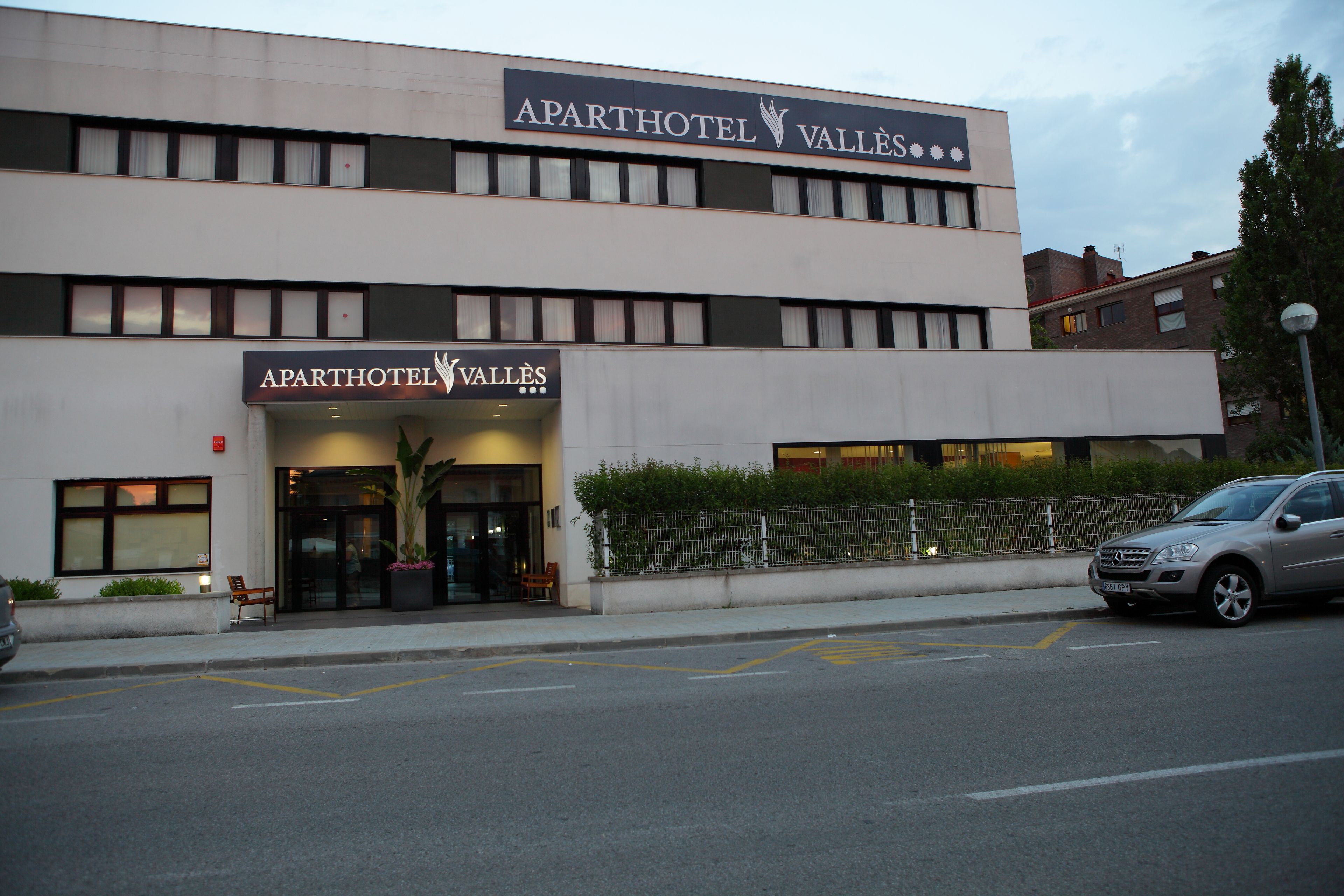 A two-story building with a sign reading "APARTHOTEL VALLÉS".