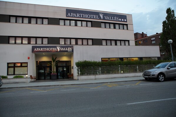 A two-story building with a sign reading "APARTHOTEL VALLÉS".