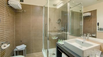 Un bagno moderno con cabina doccia in vetro, un lavandino capiente e uno specchio.