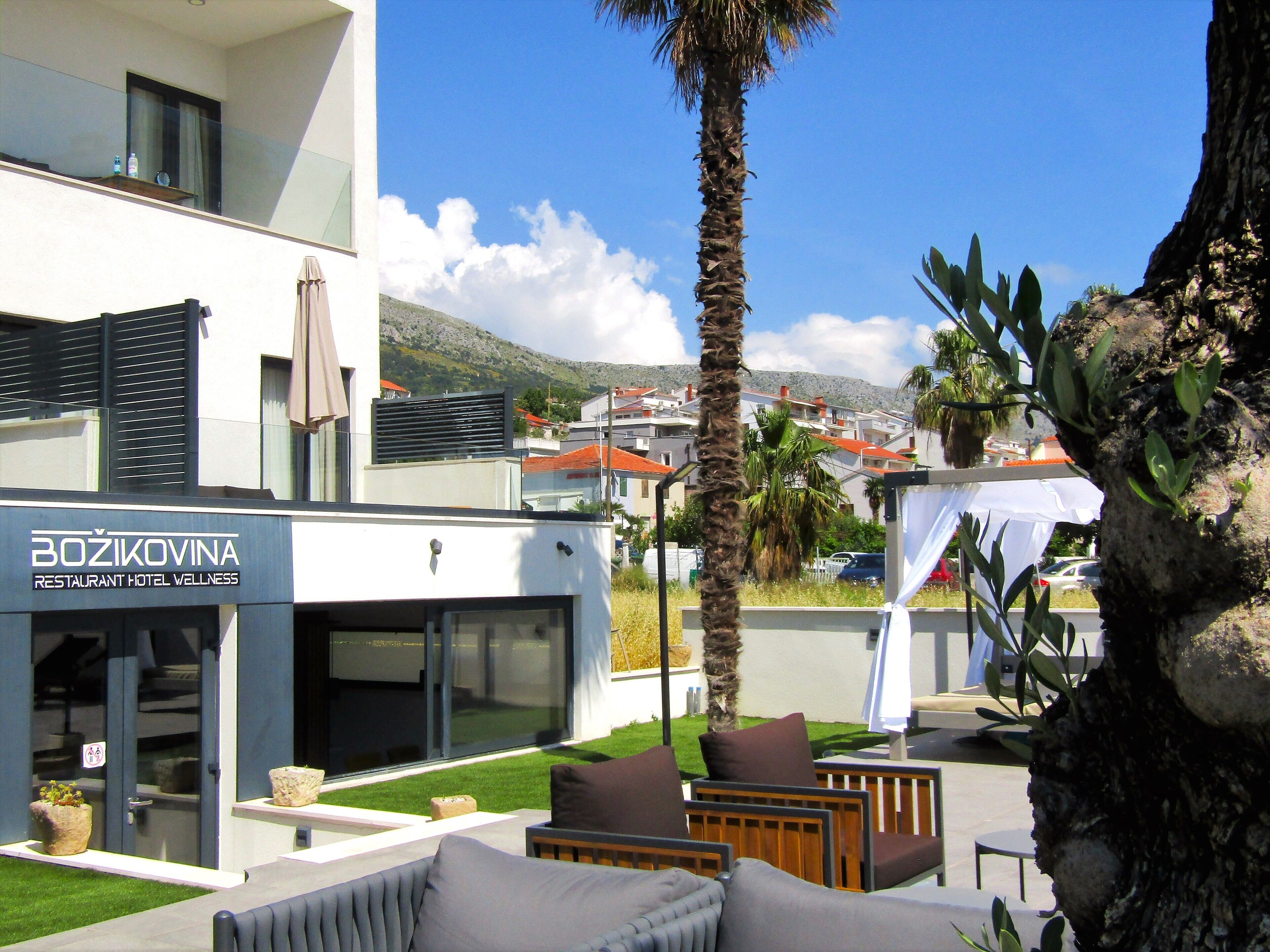 A modern building with a sign for 'Božikovina Restaurant Hotel Wellness'.