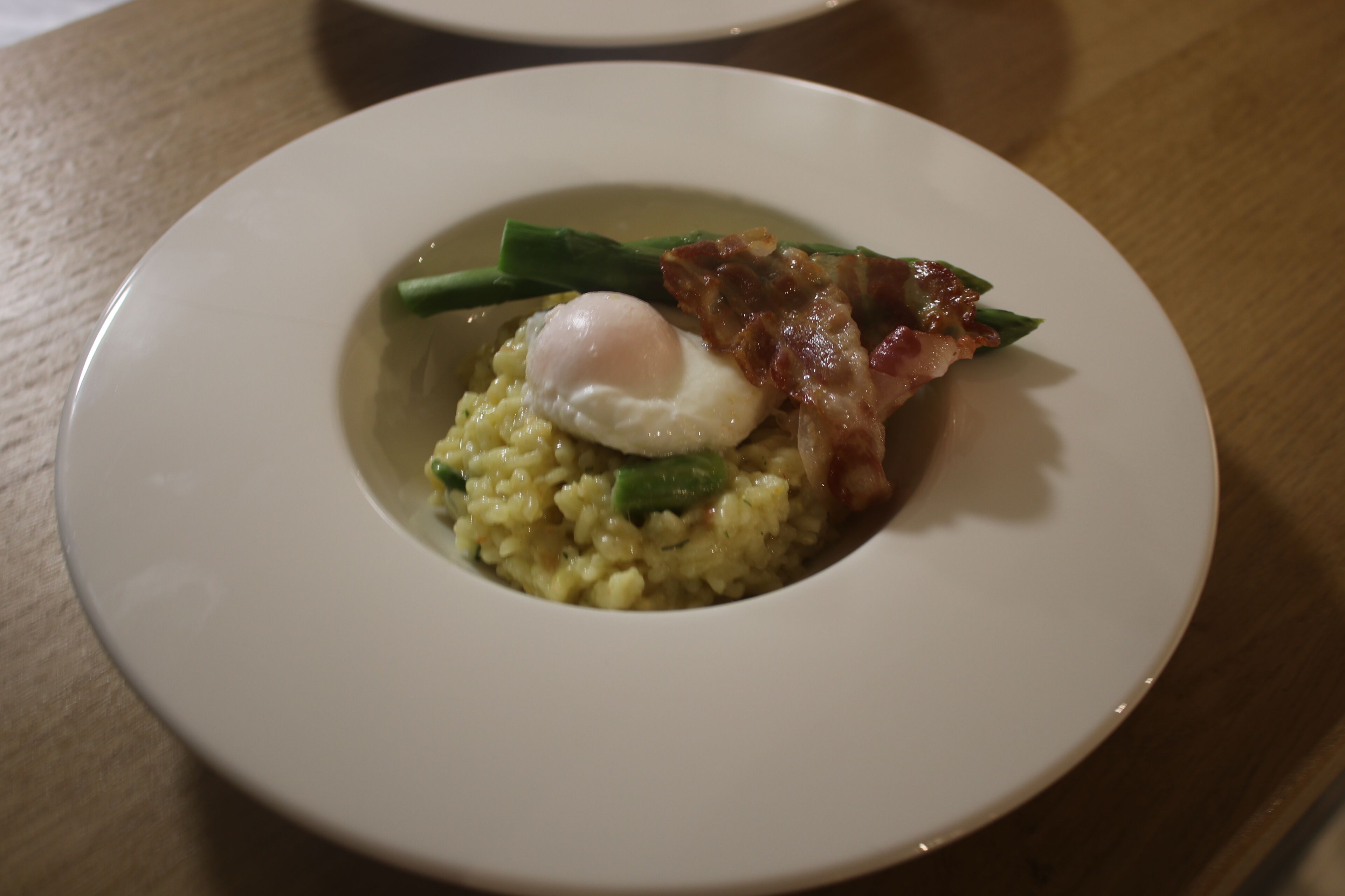 A plate of food with scrambled eggs, green beans, and bacon.