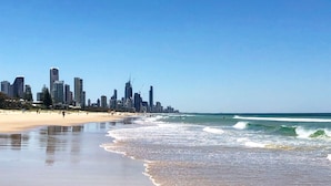 A beach with a city skyline in the background. - Marrakesh Apartments (Surfers Paradise)