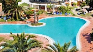 Piscine couverte, piscine extérieure, parasols de plage, chaises longues