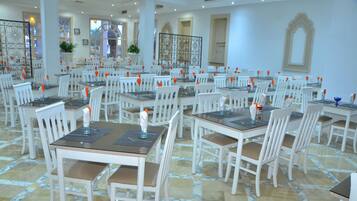 Enjoy meals in a stylish dining area with tables, chairs, and artwork.