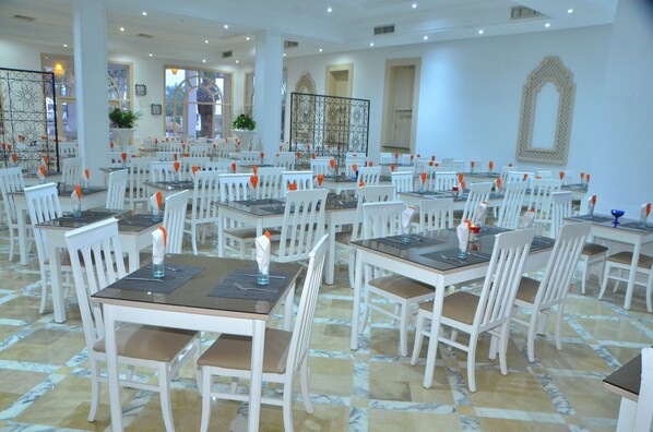 A spacious dining area with multiple tables and chairs, arranged in a grid pattern.