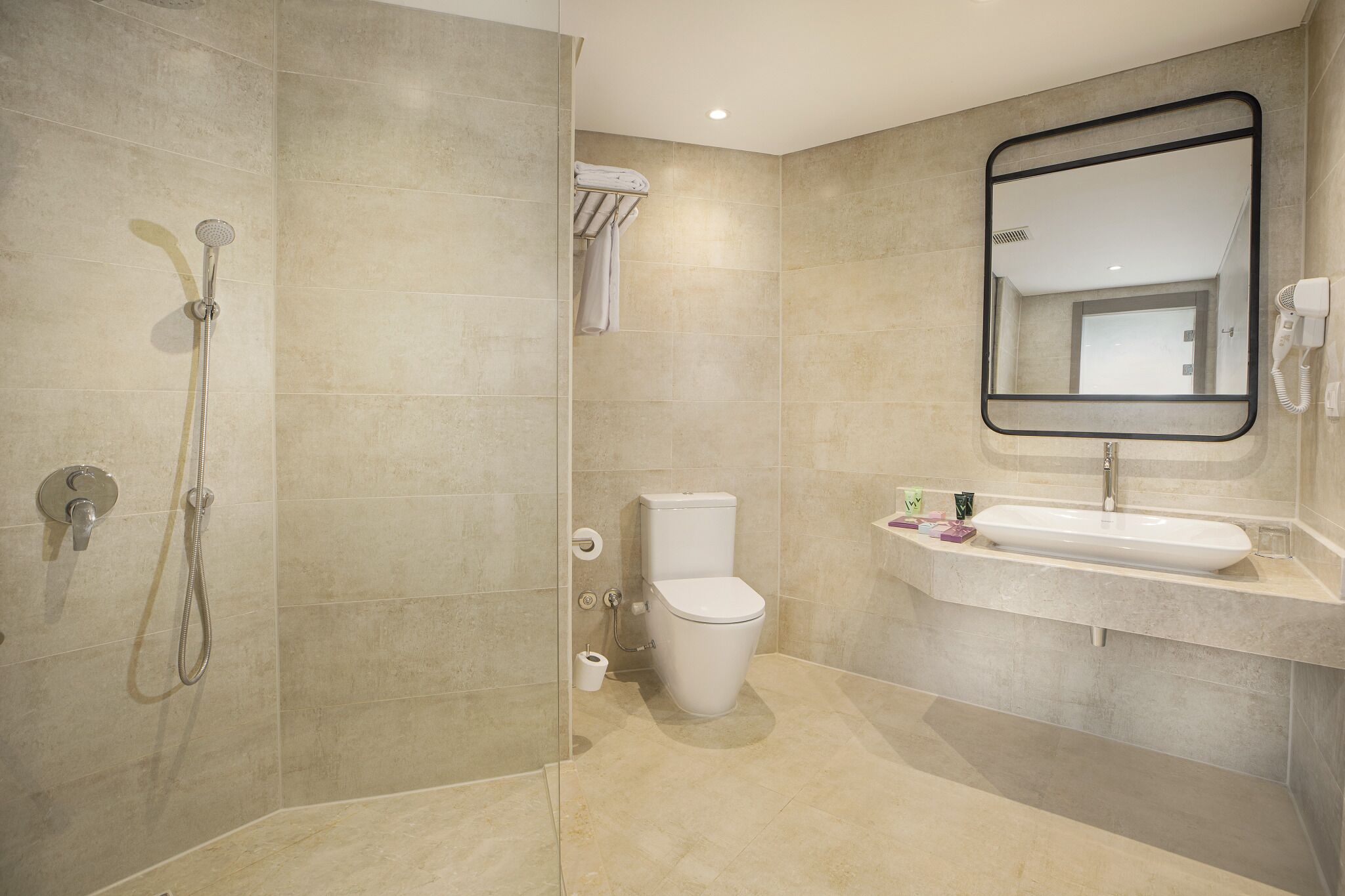A modern bathroom with a shower, toilet, and sink.