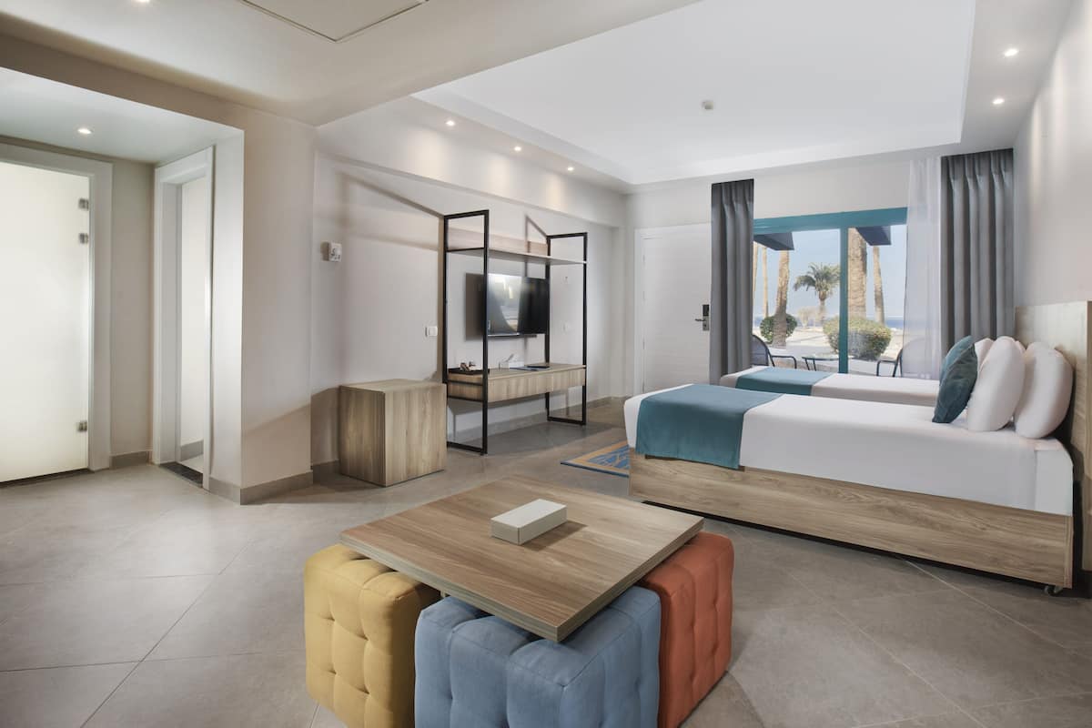 Una habitación de hotel moderna con una cama, un televisor, una mesa de madera y un sofá.