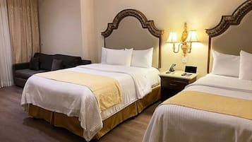 Una habitación de hotel con dos camas, un escritorio y un sofá.
