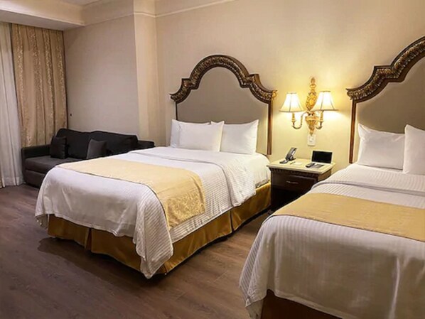 Una habitación de hotel con dos camas, un escritorio y un sofá.