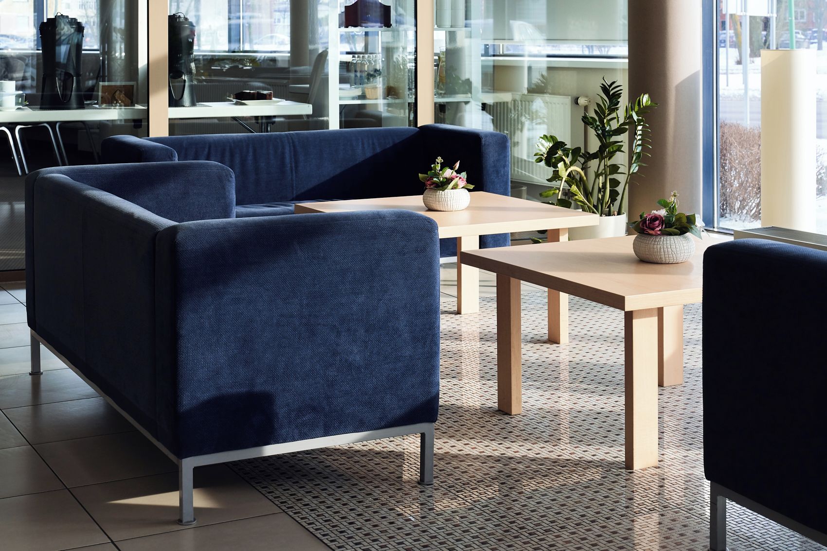 Un área de estar moderna con asientos, una mesa de centro y una planta en maceta.