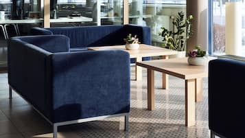 Un área de estar moderna con asientos, una mesa de centro y una planta en maceta.
