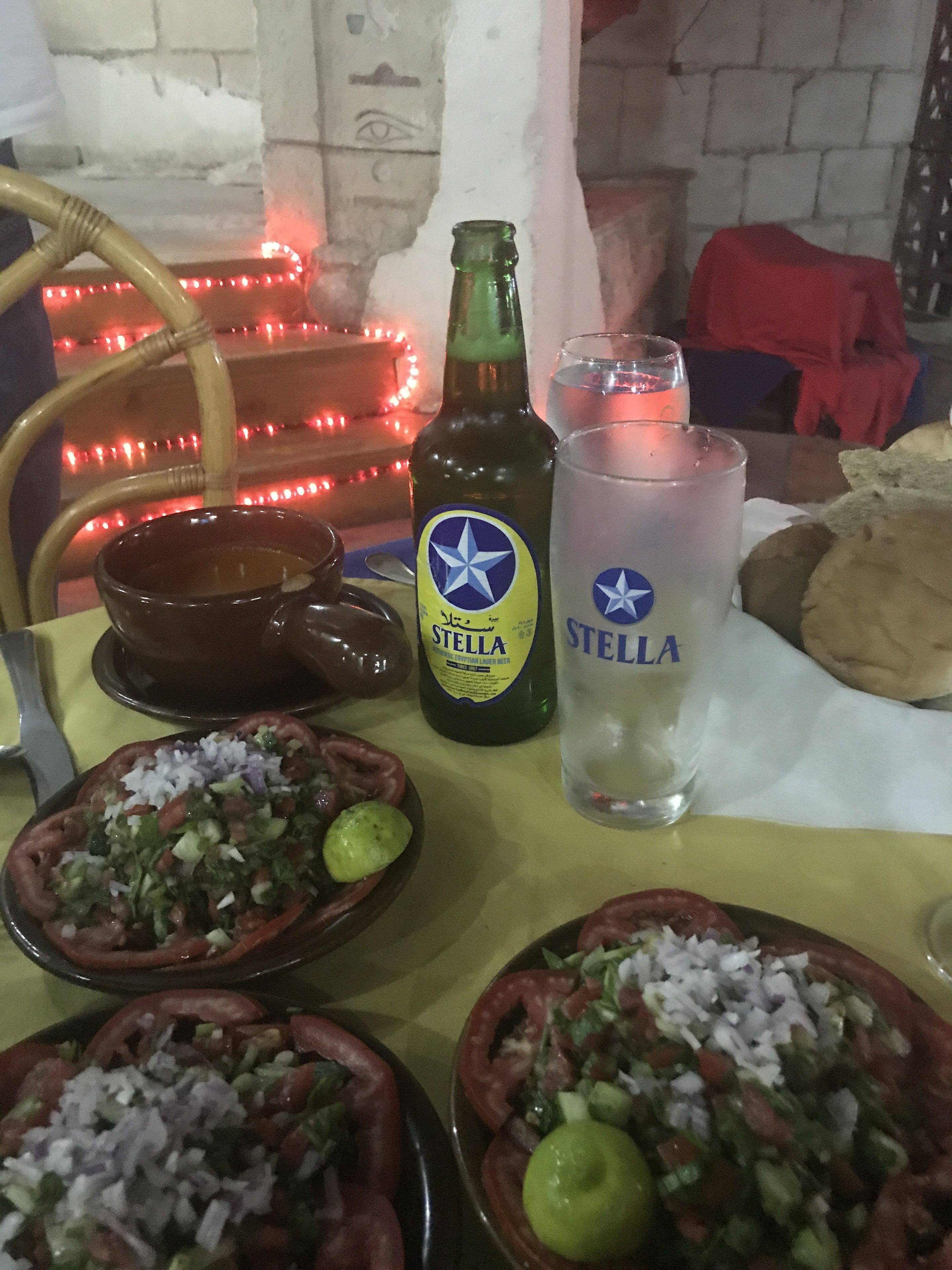 A table with food, a bottle of Stella beer, and a Stella glass.