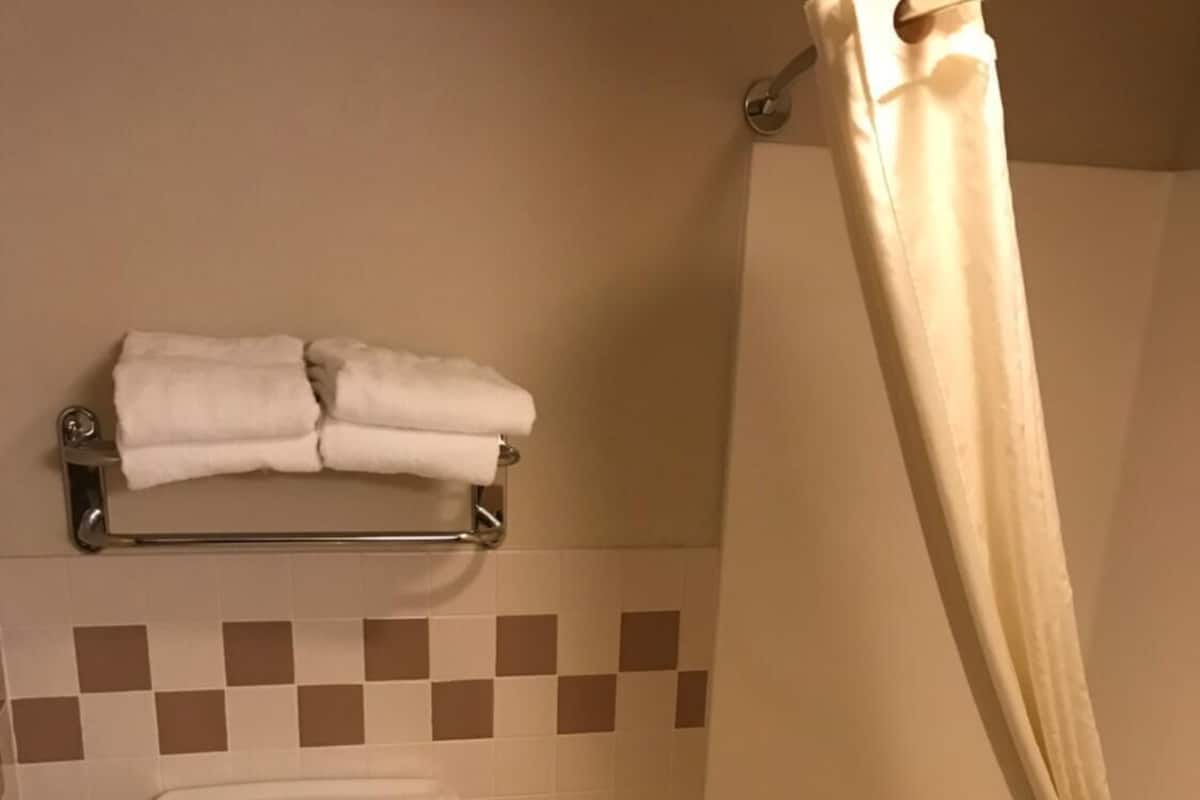 Un baño con inodoro, bañera y cortina de ducha.