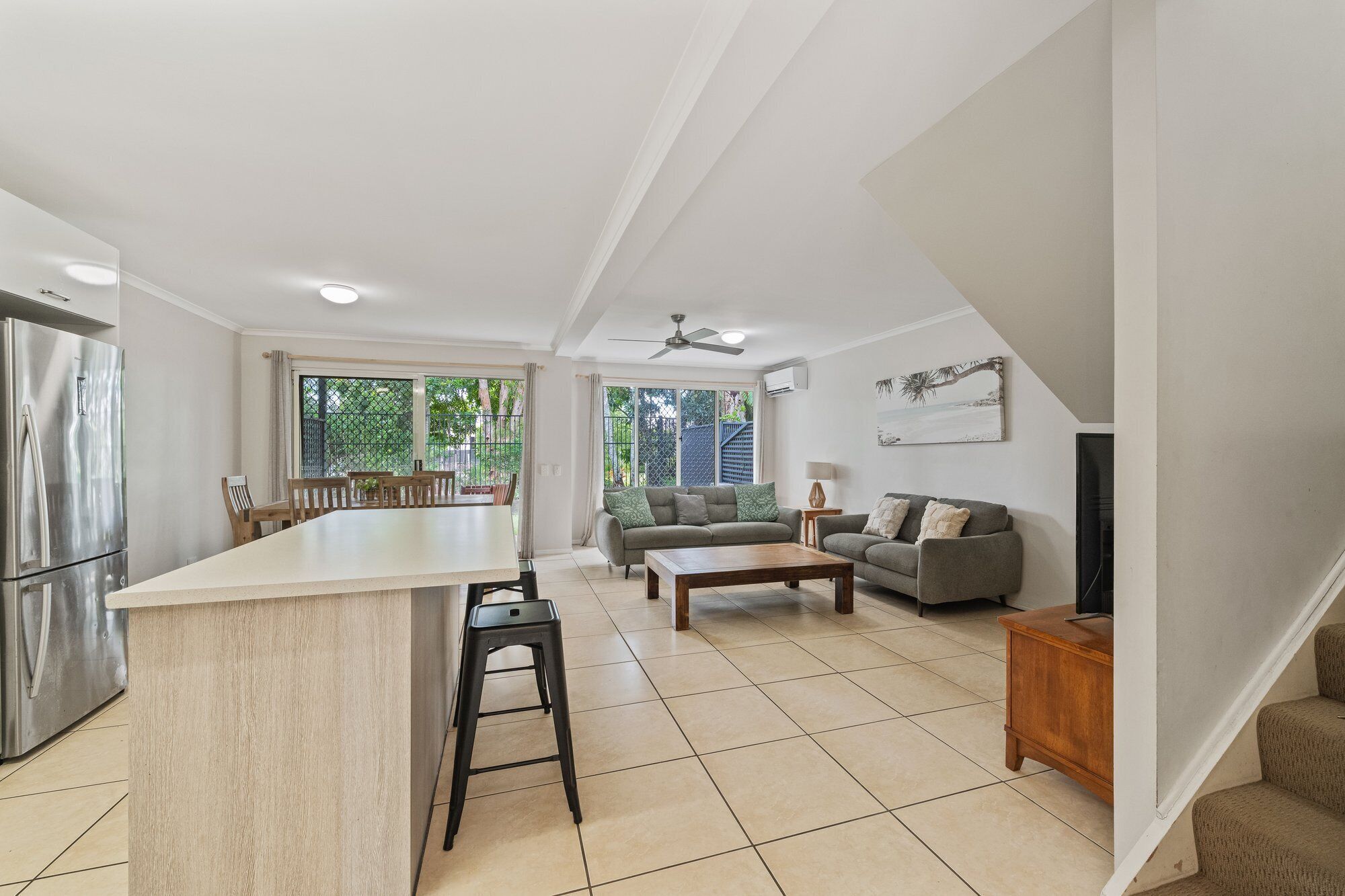 A spacious living area with a kitchen, a dining table, and a sofa.