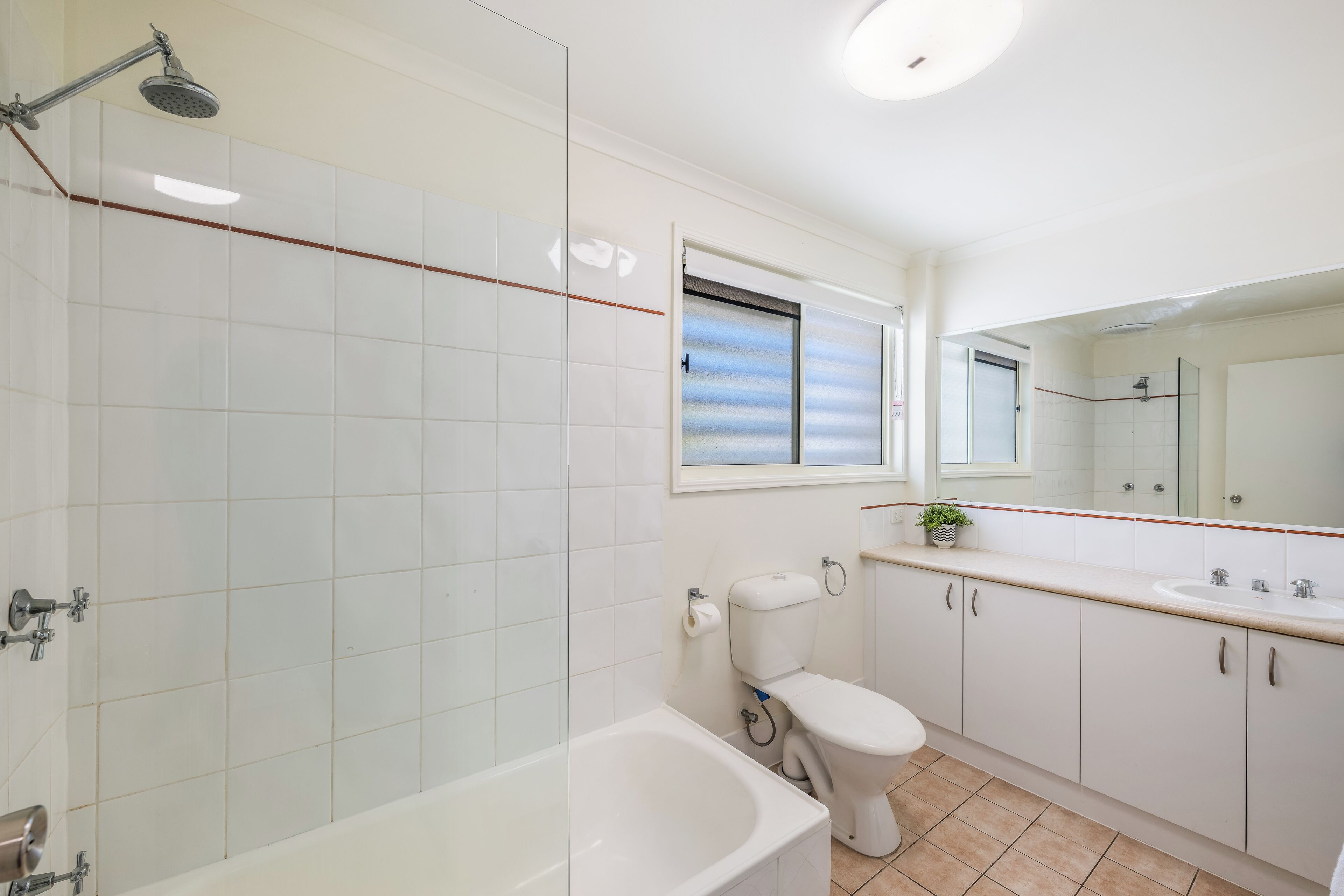 A modern bathroom with a bathtub, toilet, and sink.