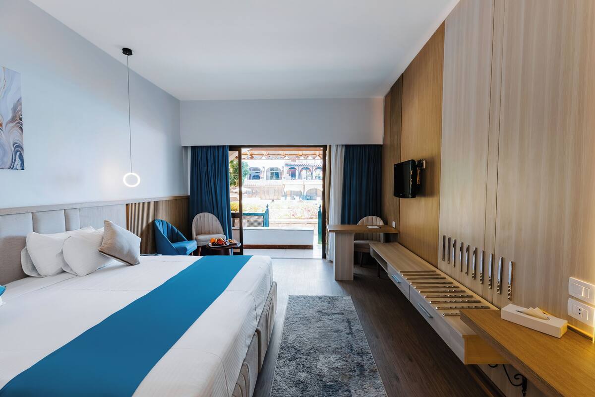 Una habitación de hotel moderna con cama, escritorio y televisor.