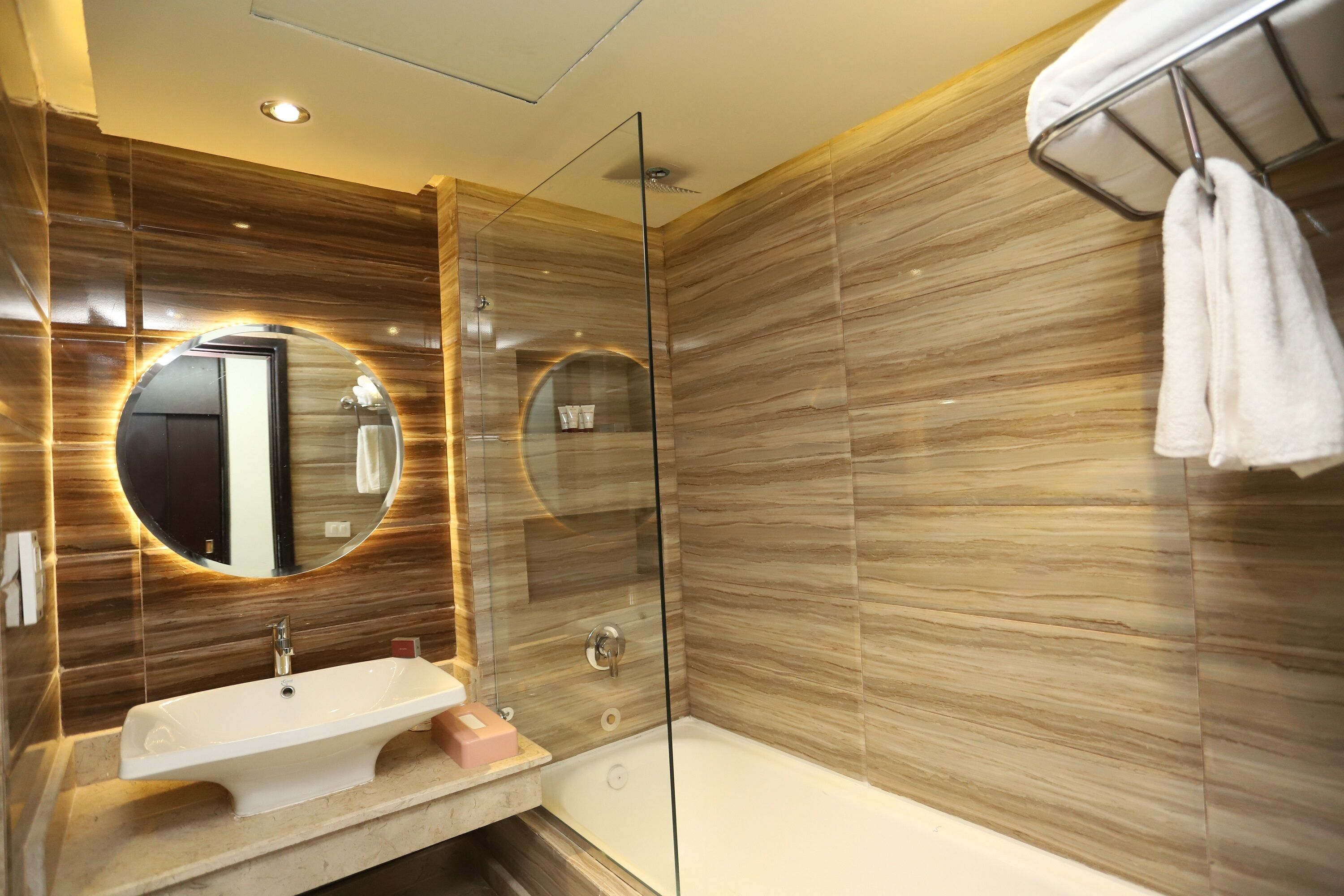 A modern bathroom with a glass shower enclosure, a sink, and a bathtub.