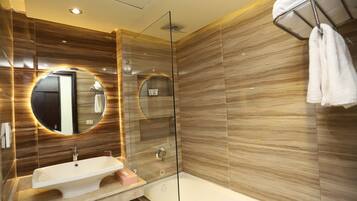 A modern bathroom with a glass shower enclosure, a sink, and a bathtub.