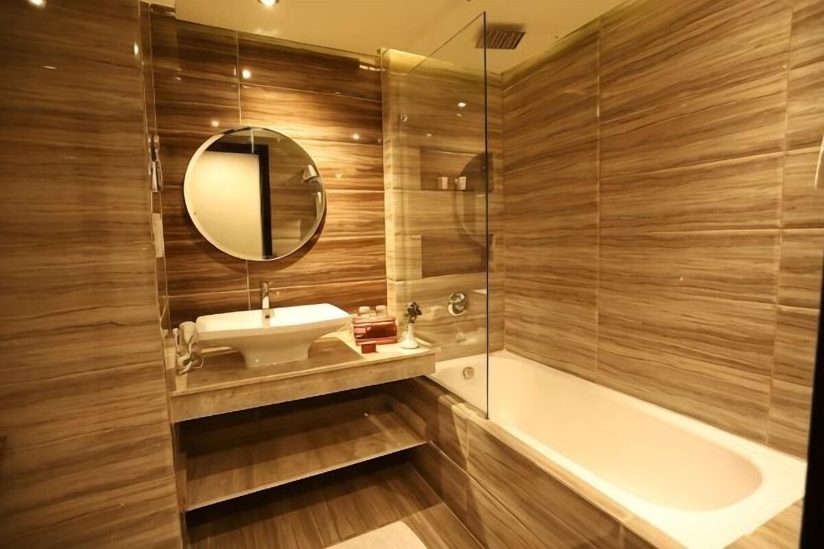 Un baño moderno con bañera, lavamanos y espejo.
