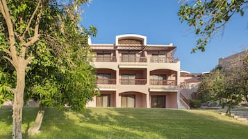 A multi-story building with balconies and a staircase leading to the entrance.