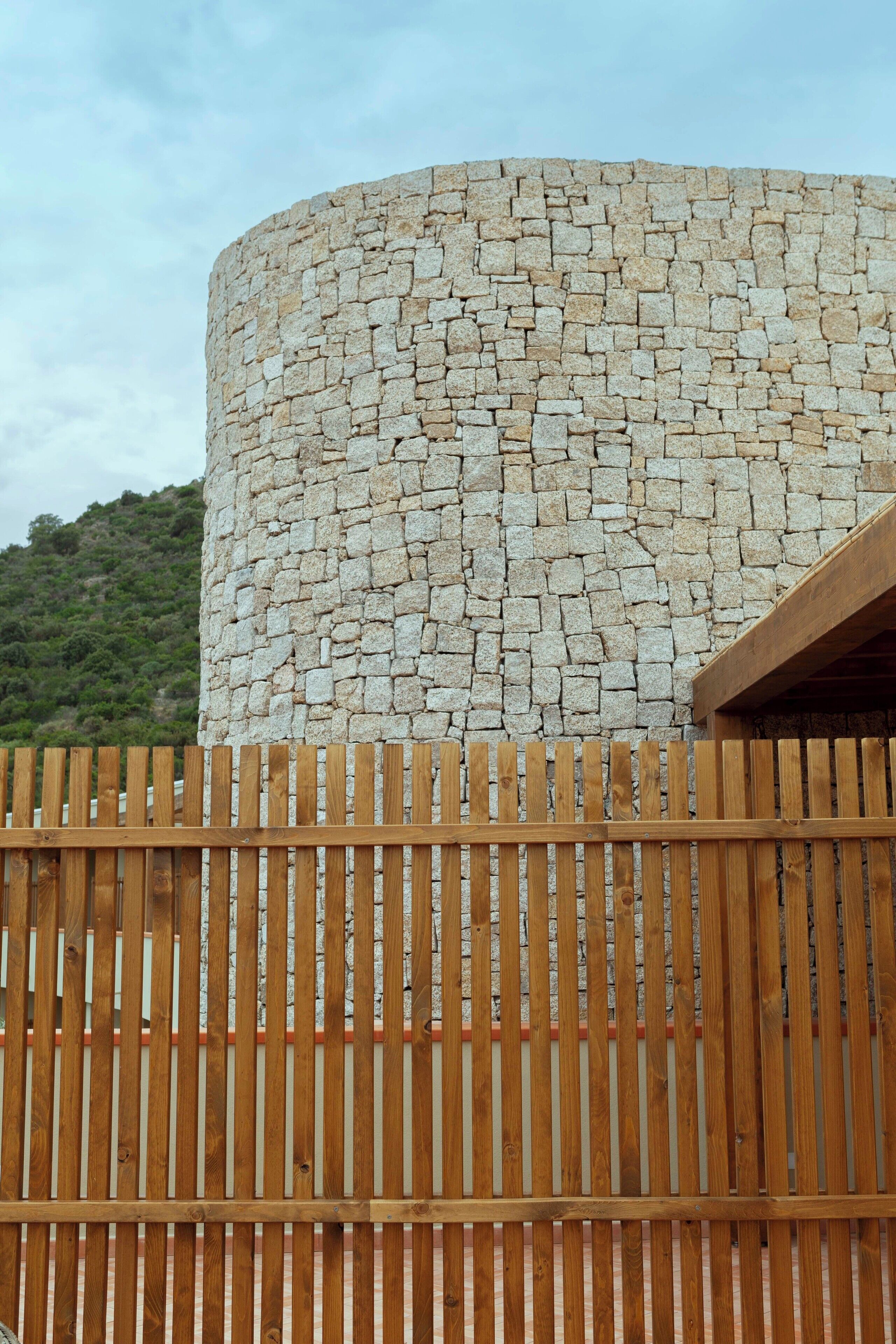 Un muro de piedra con una valla de madera al frente.
