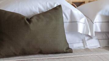 A bed with a white mattress and a green pillow.
