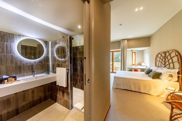 A modern bathroom with a large mirror, a shower, and a vanity with a sink. - Is Molas Resort (Pula)