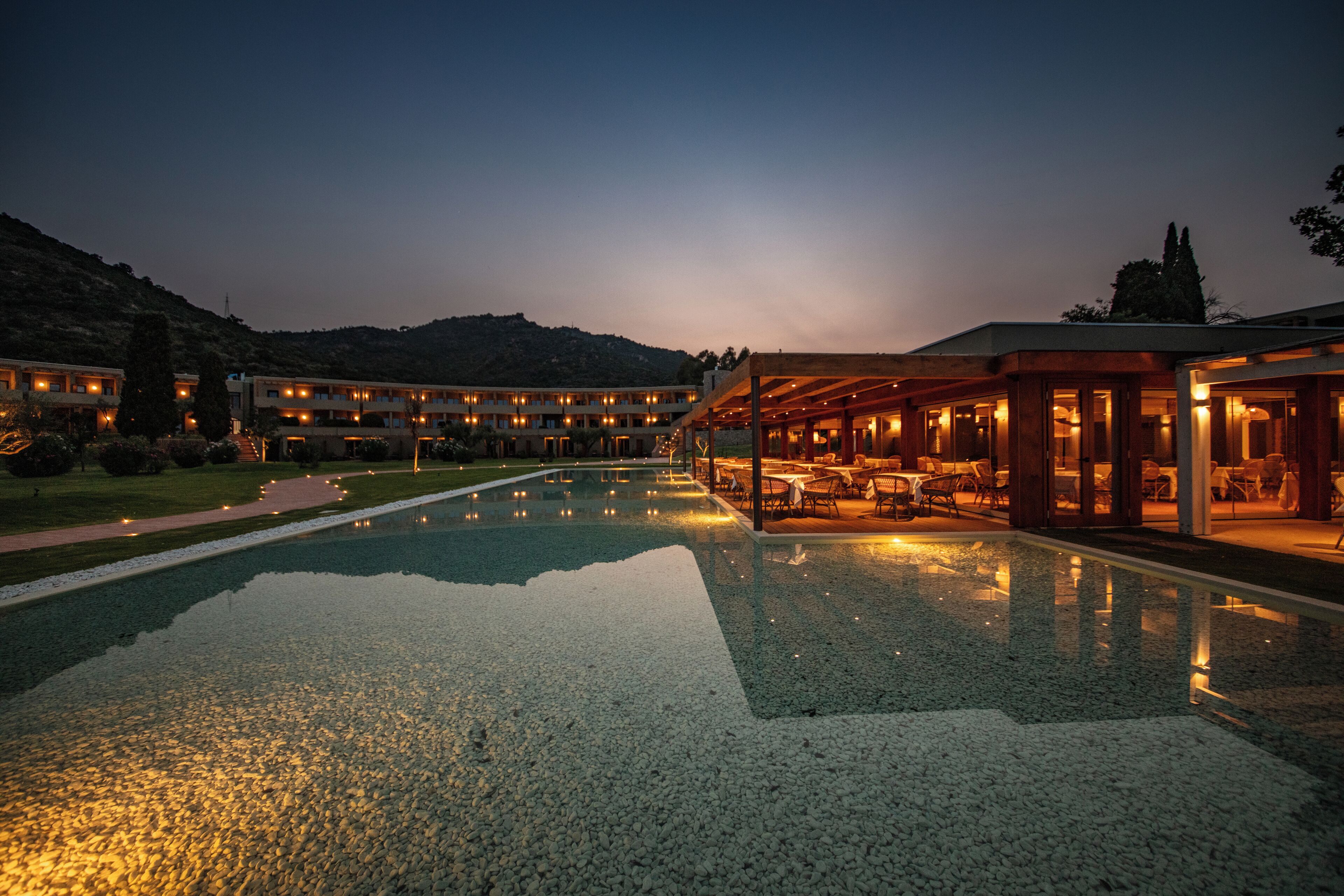Um hotel com uma piscina grande ao ar livre, várias opções de restaurantes e um cenário montanhoso.