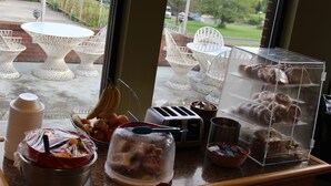 A kitchen counter with various food items, a toaster, and a view of outdoor seating. - The Stonefence Resort (Ogdensburg)